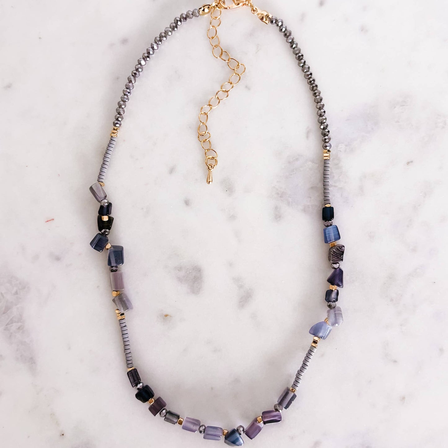 Necklace with multicolored beads on a marble surface