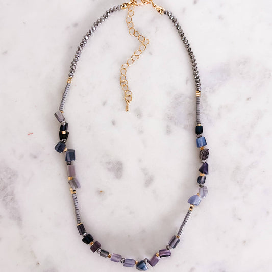 Necklace with multicolored beads on a marble surface